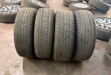Load image into Gallery viewer, Set of Used '22-'26 Toyota Tundra OEM TRD Black Wheels on 265/60R20 Falken AT LT