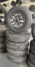 Load image into Gallery viewer, OEM '07-'26 Jeep Wrangler 17" Dark Charcoal Rims 245/75R17 Bridgestone HT Tires