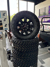 Load image into Gallery viewer, Set of &#39;11-&#39;25 GMC Sierra 2500 Black Wheels on 35/12.50R20 Nitto Trail Grappler
